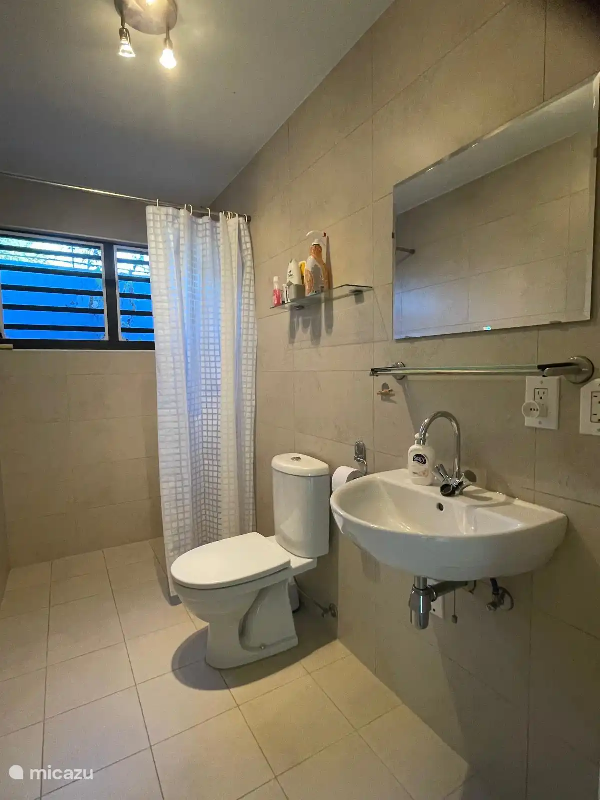 Salle de bain avec douche à effet pluie et approvisionnement en eau chaude.
