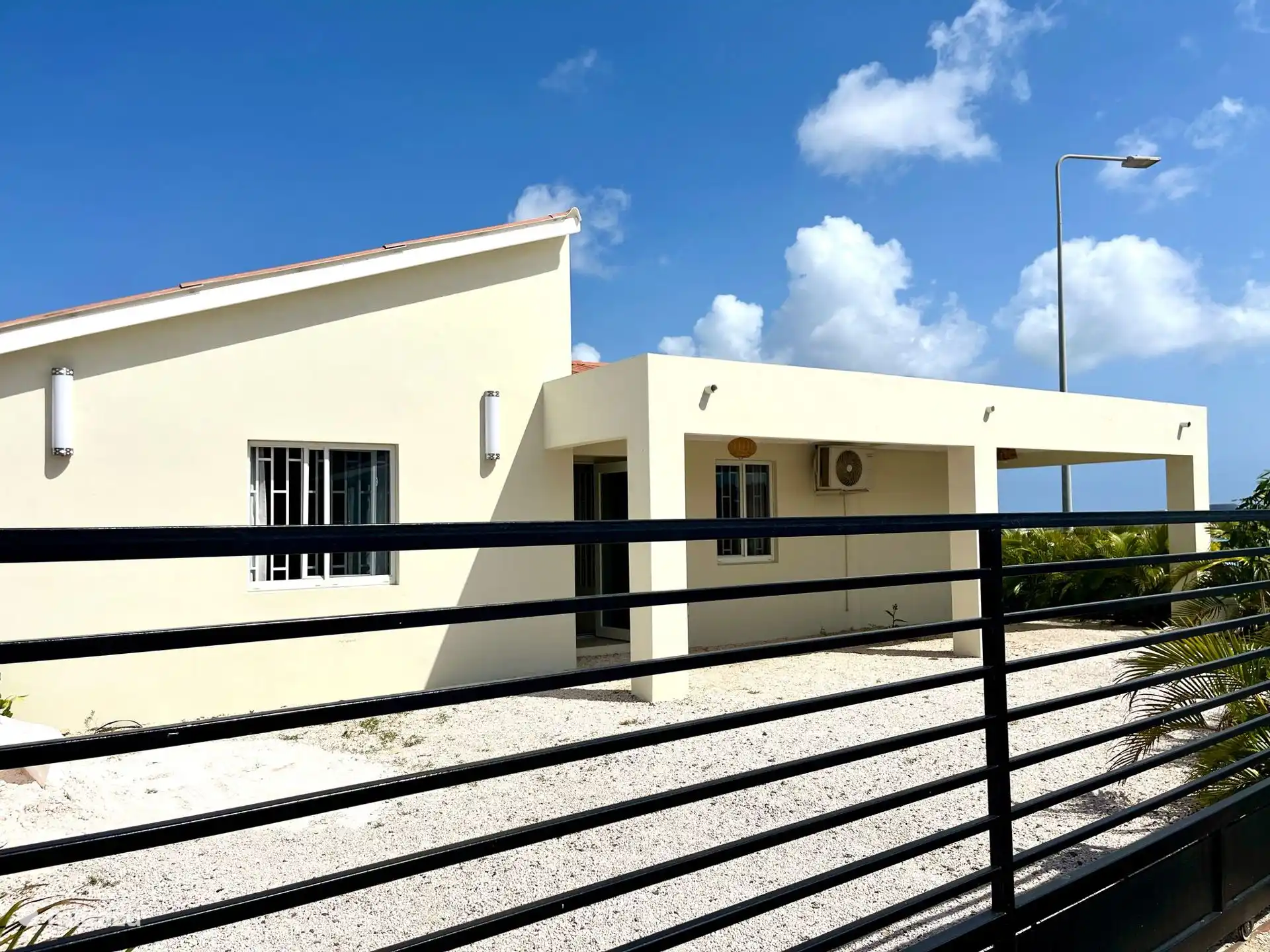 La puerta de entrada y el espacio de estacionamiento para hasta 2 autos.