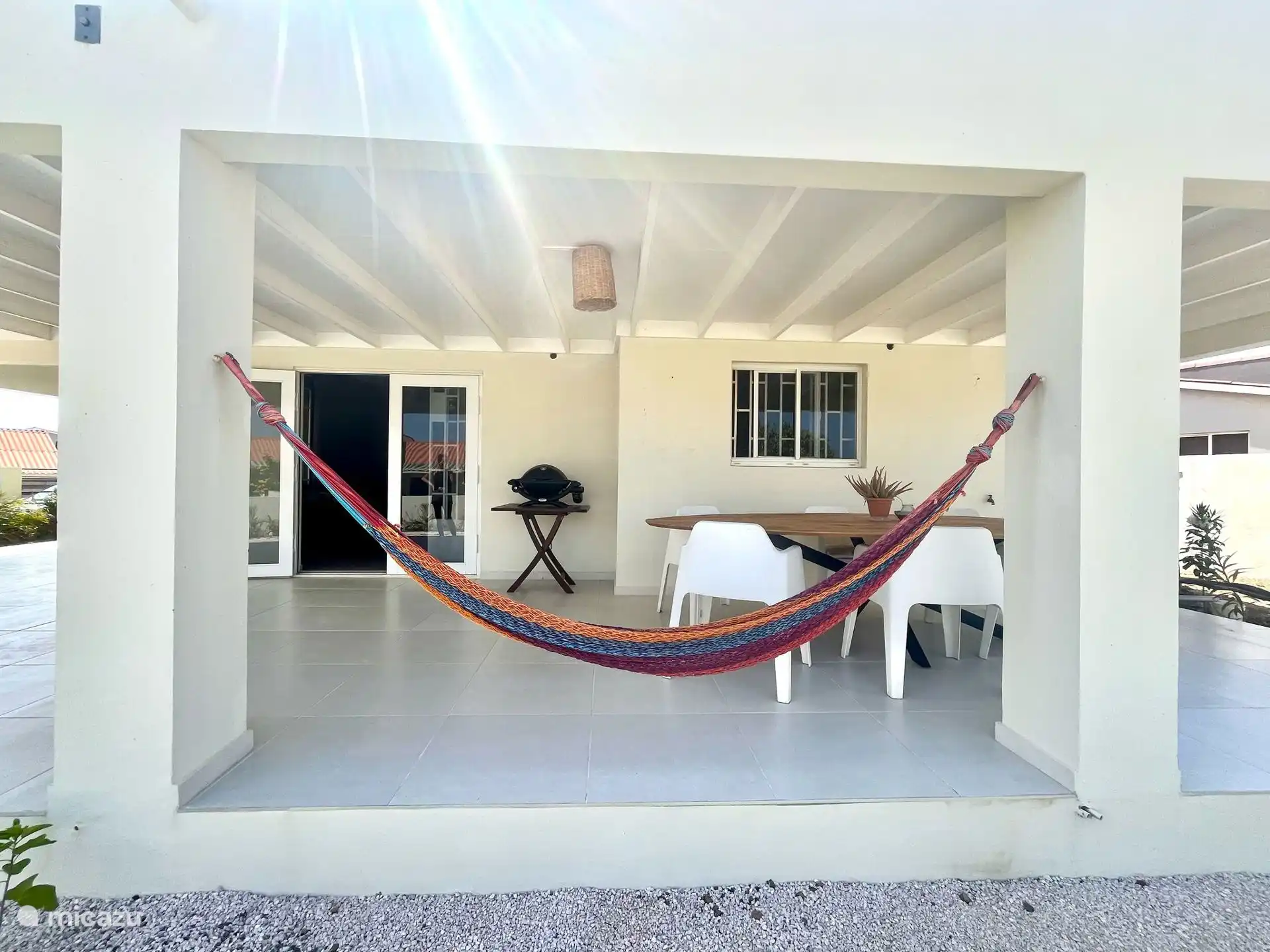 Amplio porche con una gran mesa de comedor para 6 personas, una acogedora hamaca, barbacoa e impresionantes vistas de Tafelberg, el lugar perfecto para relajarse y cenar al aire libre.