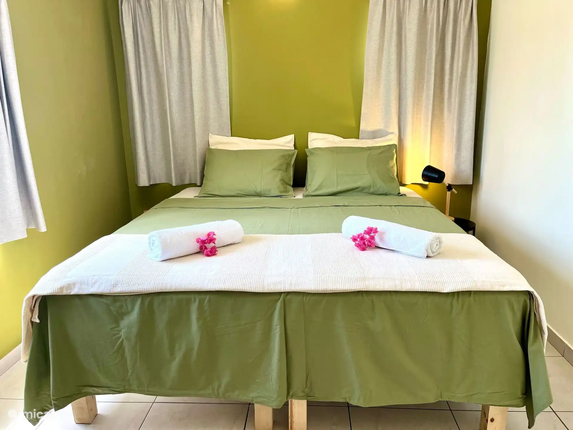 Dormitorio verde: cuenta con una cómoda cama queen, aire acondicionado y un armario para almacenamiento.