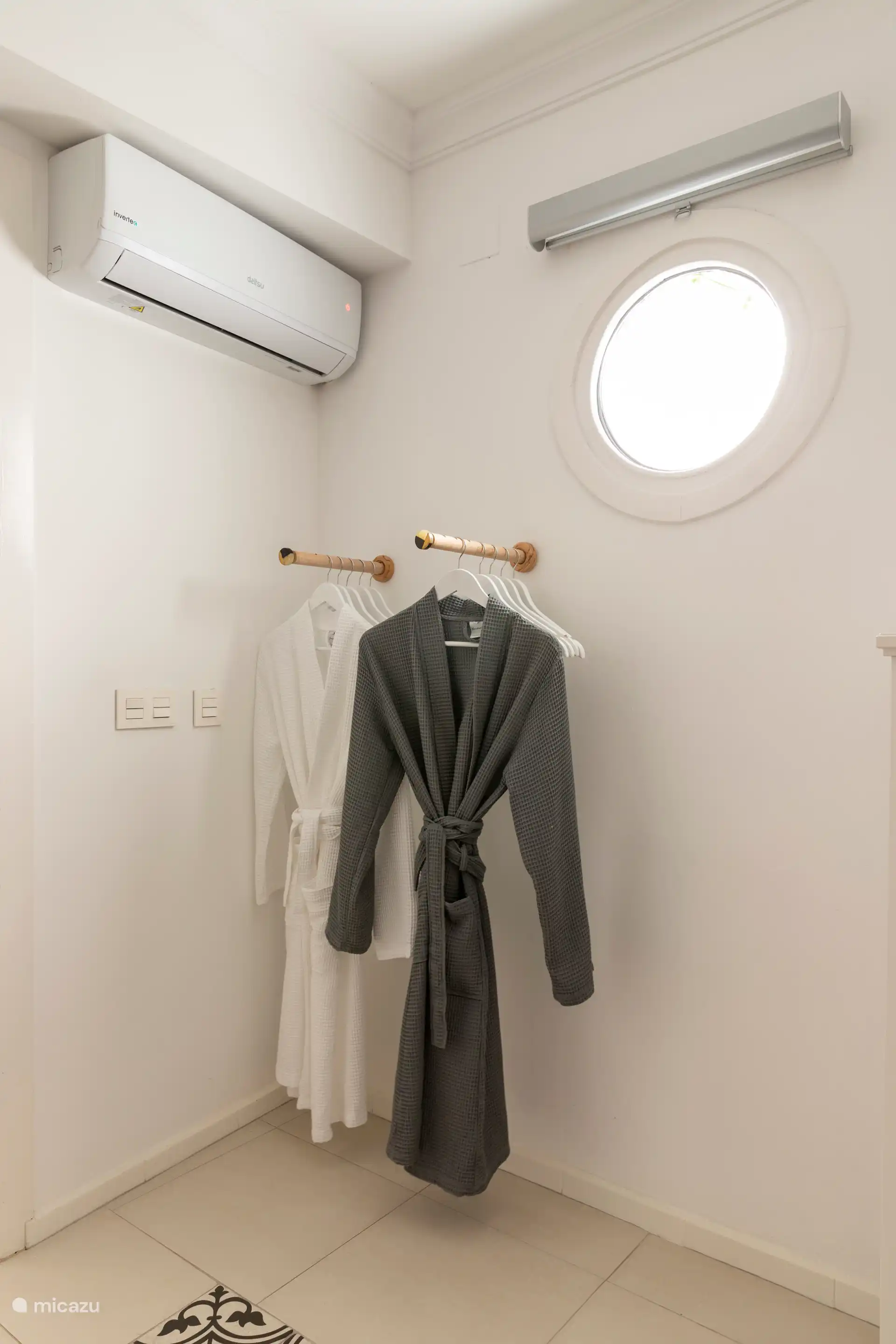 Chambre spacieuse avec lit double, serviettes, tables de chevet, commode, chaise, miroir et peignoirs.