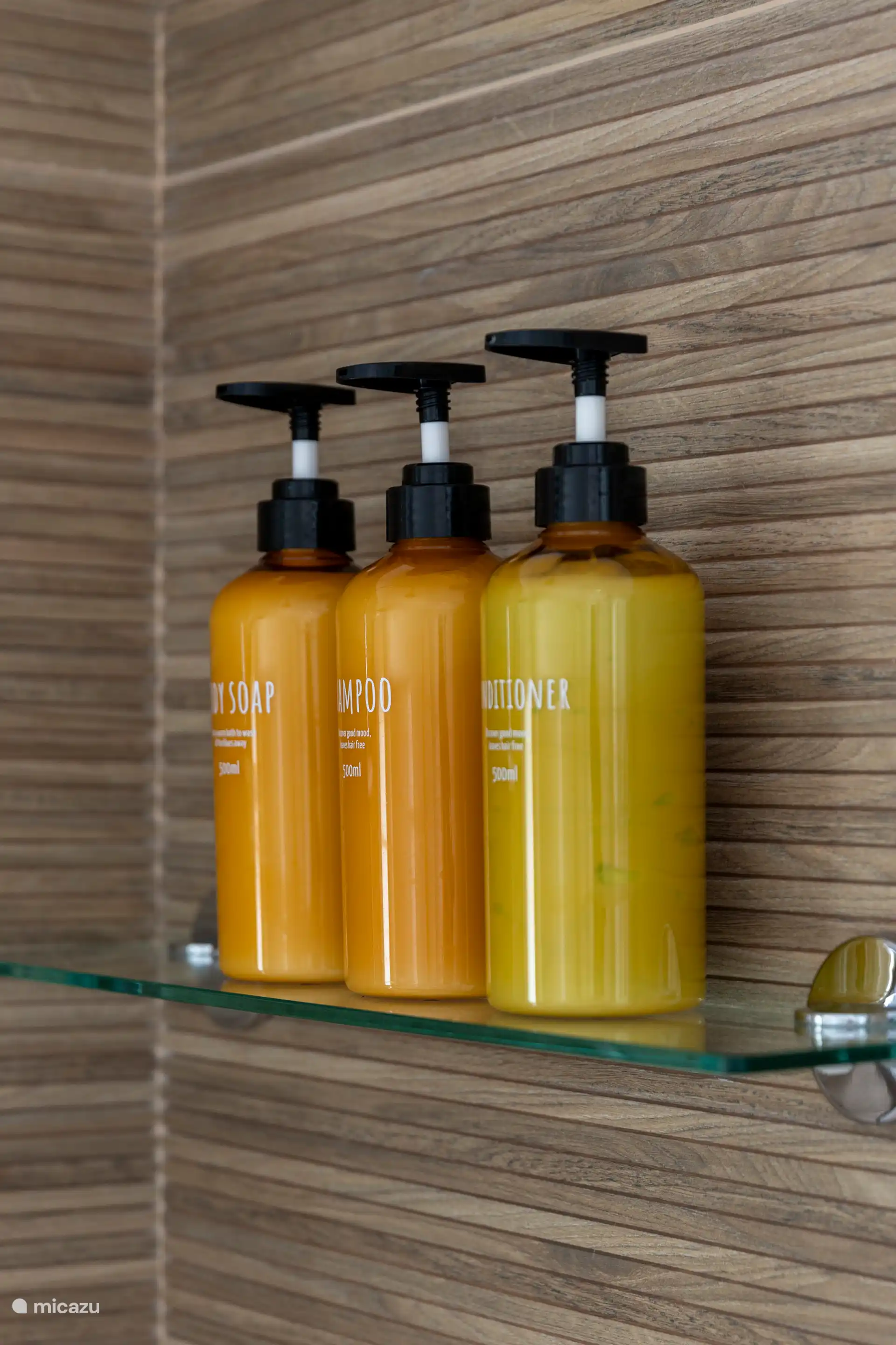 Salle de bain spacieuse avec douche à l’italienne, toilettes, lavabo, miroir, chauffe-serviettes et articles de toilette.