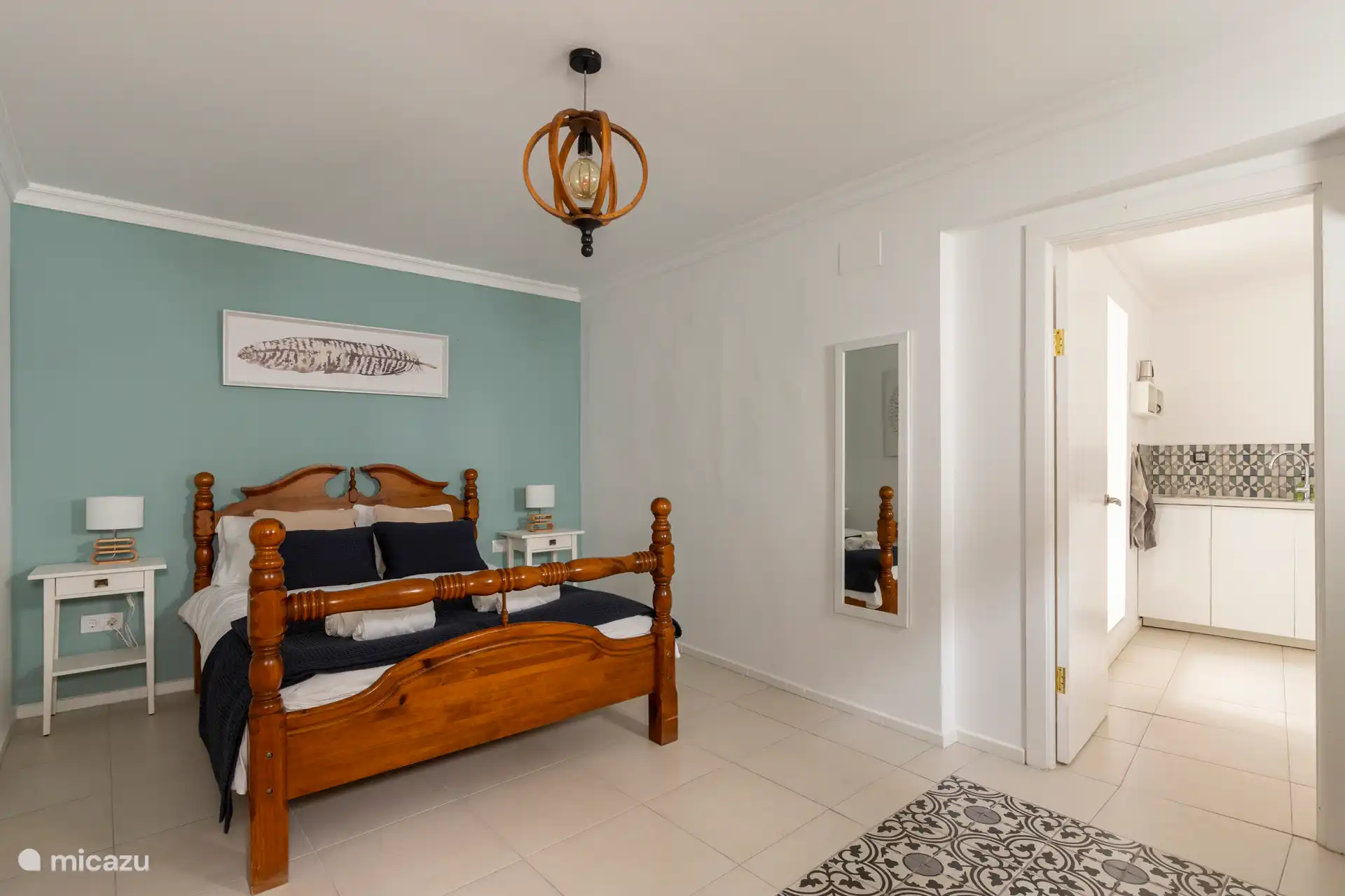 Chambre spacieuse avec lit double, serviettes, tables de chevet, commode, chaise, miroir et peignoirs.