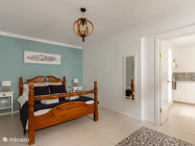Victoria Seis - Appartement La Luz | Espagne, Andalousie, Medina Sidonia - appartement Chambre spacieuse avec lit double, serviettes, tables de chevet, commode, chaise, miroir et peignoirs.