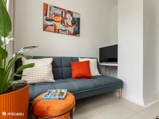 Victoria Seis - Appartement La Luz | Espagne, Andalousie, Medina Sidonia - appartement Petit salon avec une télévision, un fauteuil confortable et un canapé-lit pouvant accueillir 1 enfant (le canapé mesure 1,70 m de long)