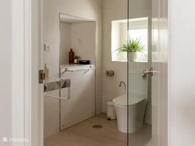 Victoria Seis - Appartement La Luz | Espagne, Andalousie, Medina Sidonia - appartement Salle de bain spacieuse et moderne avec douche à l’italienne, toilettes, lavabo, miroir, chauffage des serviettes et articles de toilette.