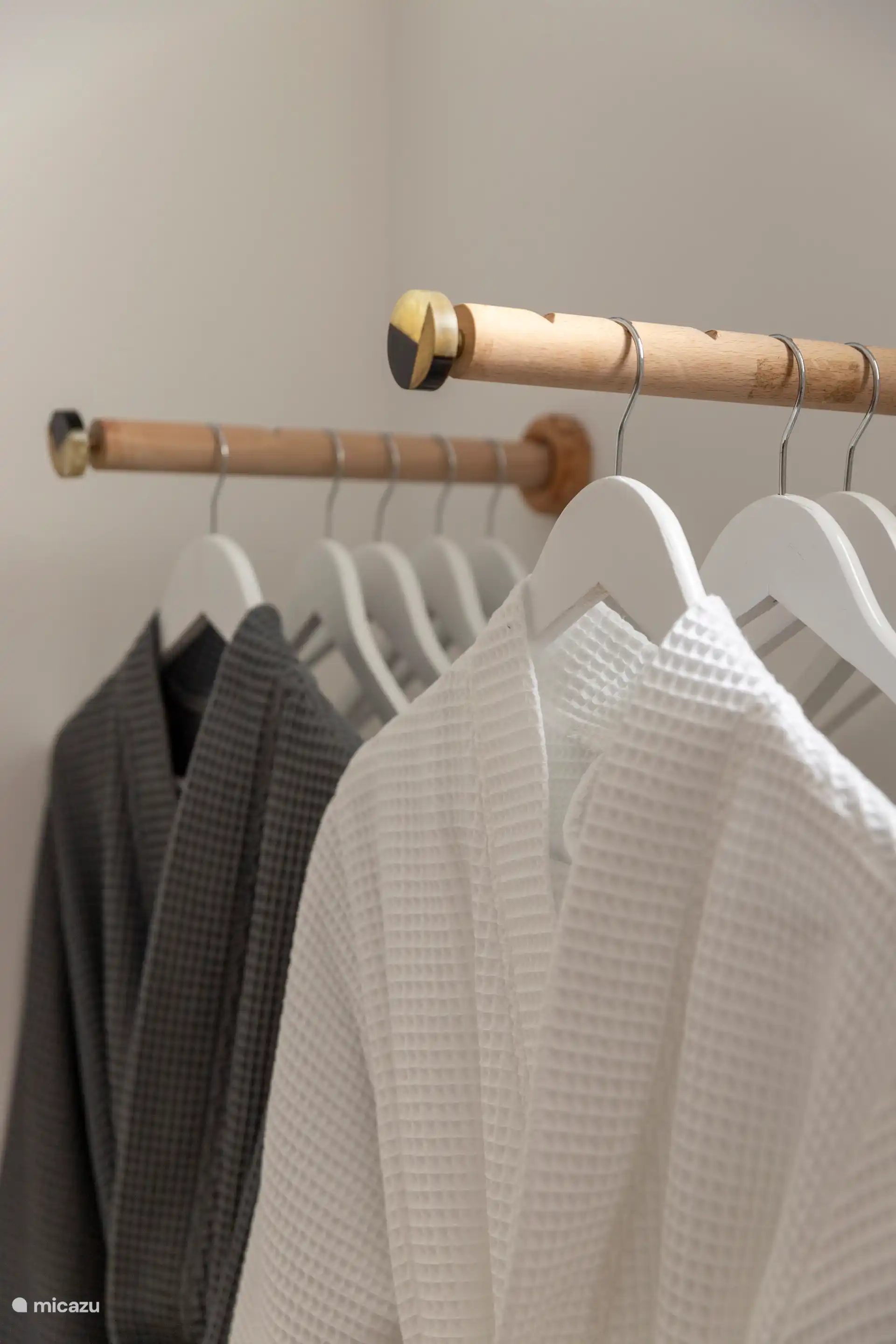 Chambre spacieuse avec lit double, serviettes, tables de chevet, commode, chaise, miroir et peignoirs.