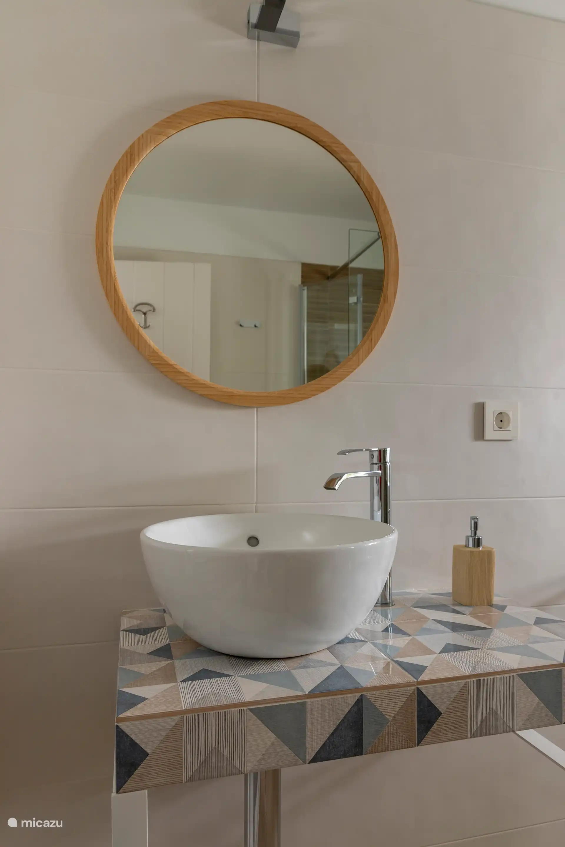 Salle de bain spacieuse avec douche à l’italienne, toilettes, lavabo, miroir, chauffe-serviettes et articles de toilette.