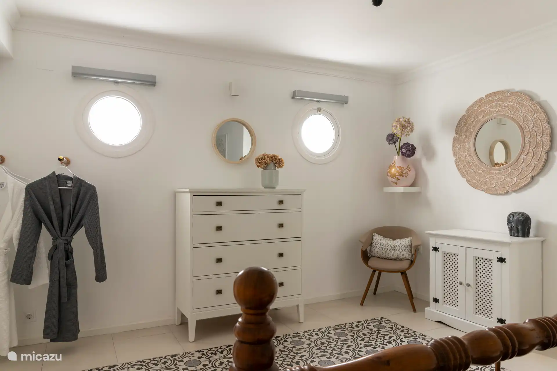 Chambre spacieuse avec lit double, serviettes, tables de chevet, commode, chaise, miroir et peignoirs.