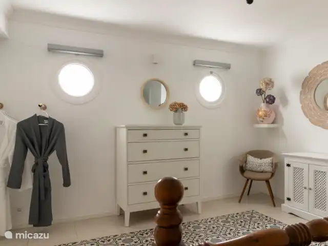 Victoria Seis - Appartement La Luz | Espagne, Andalousie, Medina Sidonia - appartement Chambre spacieuse avec lit double, serviettes, tables de chevet, commode, chaise, miroir et peignoirs.