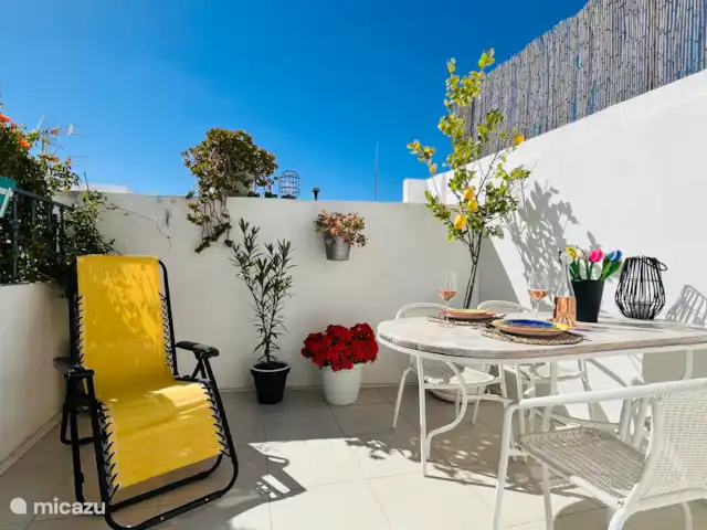 Victoria Seis - Appartement La Luz | Espagne, Andalousie, Medina Sidonia - appartement Terrasse privée avec table avec 4 chaises, chaise confortable, parasol, plantes et corde à linge.