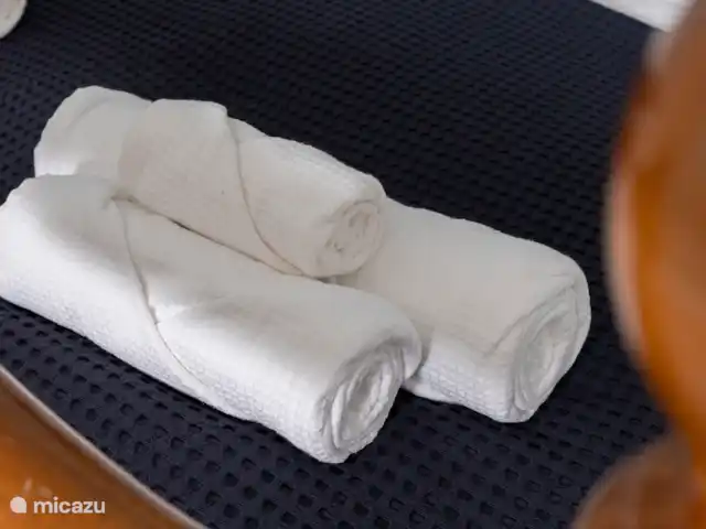Victoria Seis - Appartement La Luz | Espagne, Andalousie, Medina Sidonia - appartement Chambre spacieuse avec lit double, serviettes, tables de chevet, commode, chaise, miroir et peignoirs.