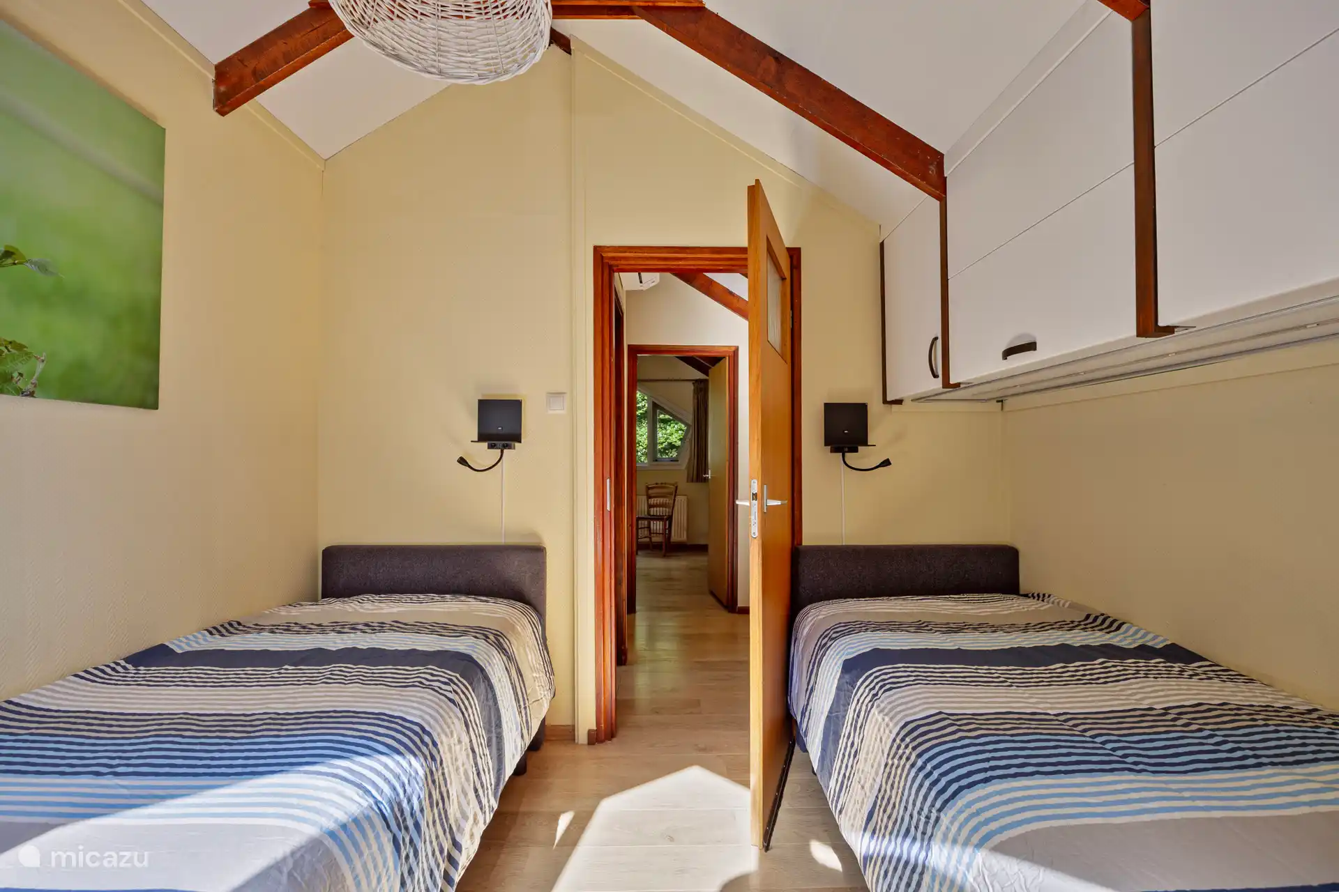 Slaapkamer met twee boxspring bedden.