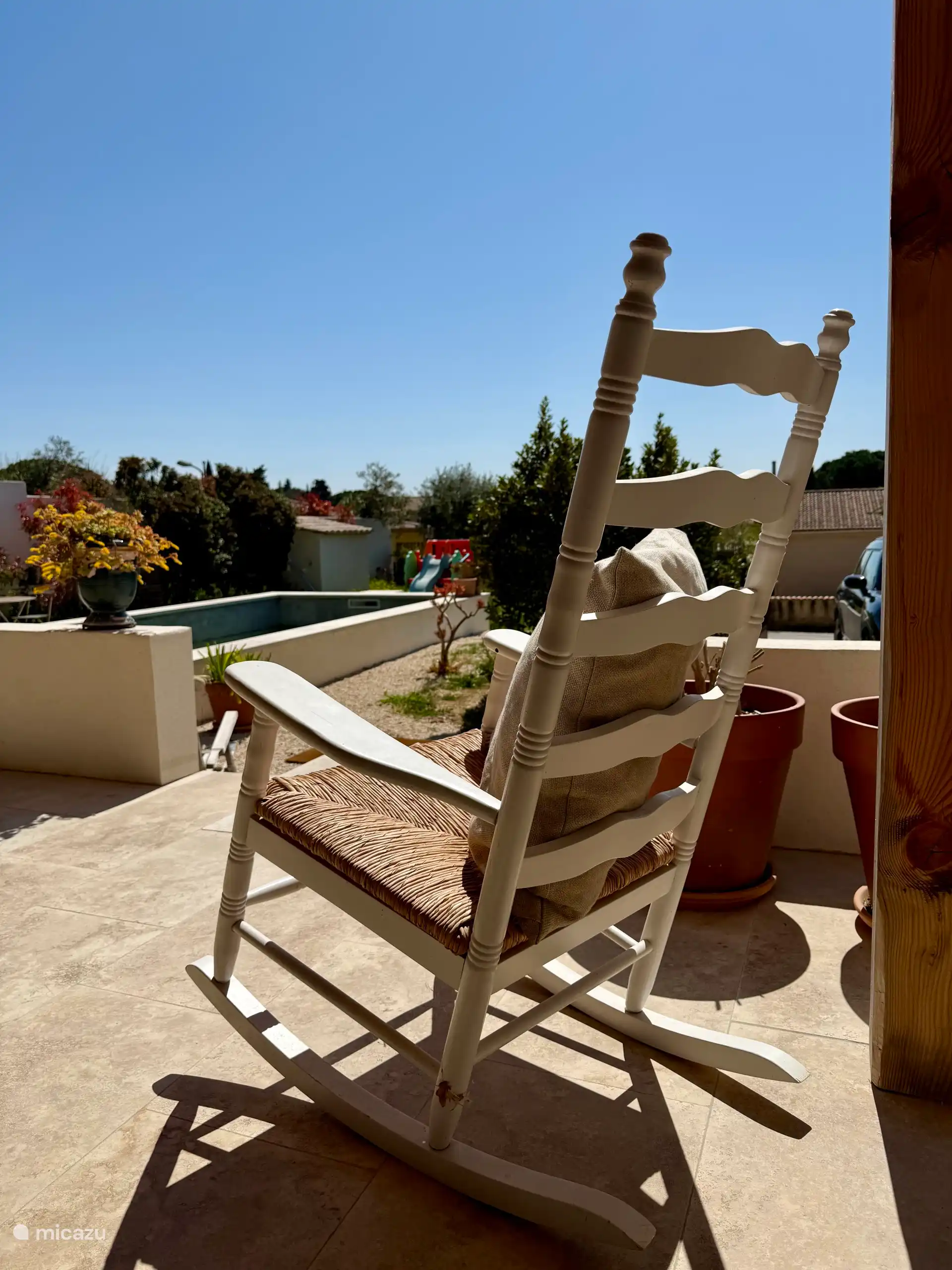 fauteuil à bascule pour une moment de repos au soleil sur la terrasse lequel surplombe le jardin et la piscine