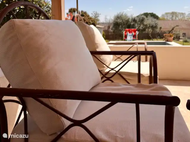 Las cigarras de St-Quentin-la-Poterie en Francia, Gard, Saint-Quentin-la-Poterie - casa vacacional un sofá y 2 sillones de exterior para la terraza cubierta.