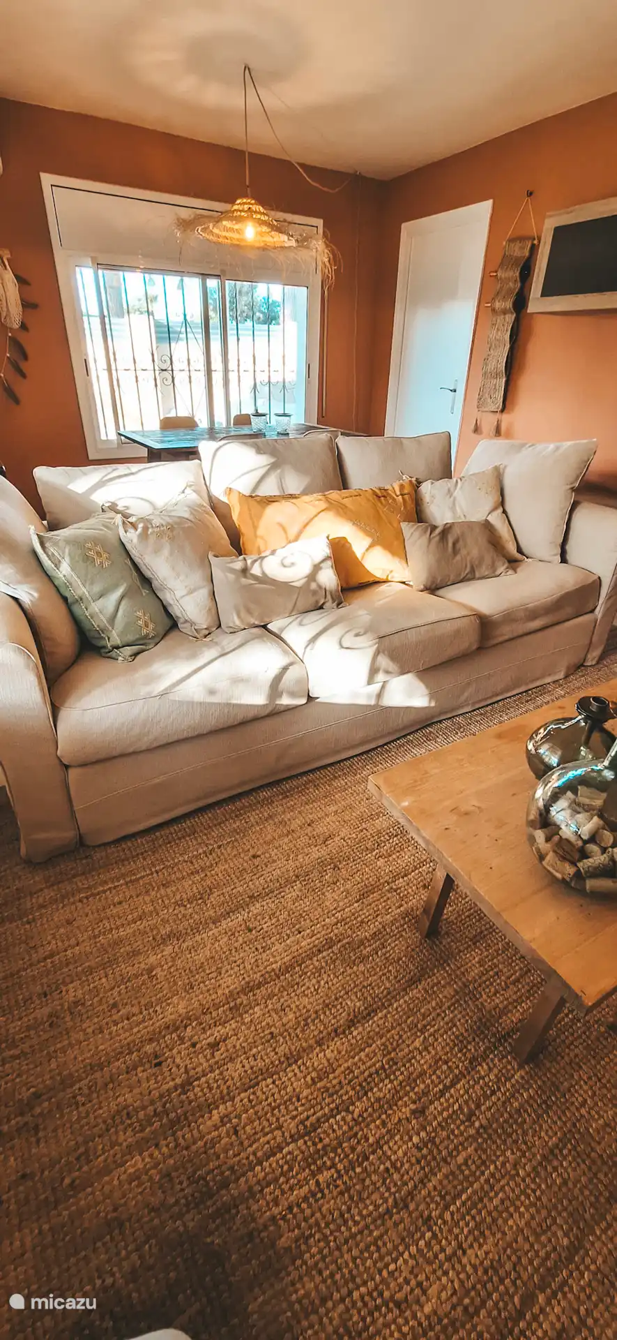 Gemütliches Wohnzimmer mit geräumigem Sofa und dem Esstisch dahinter