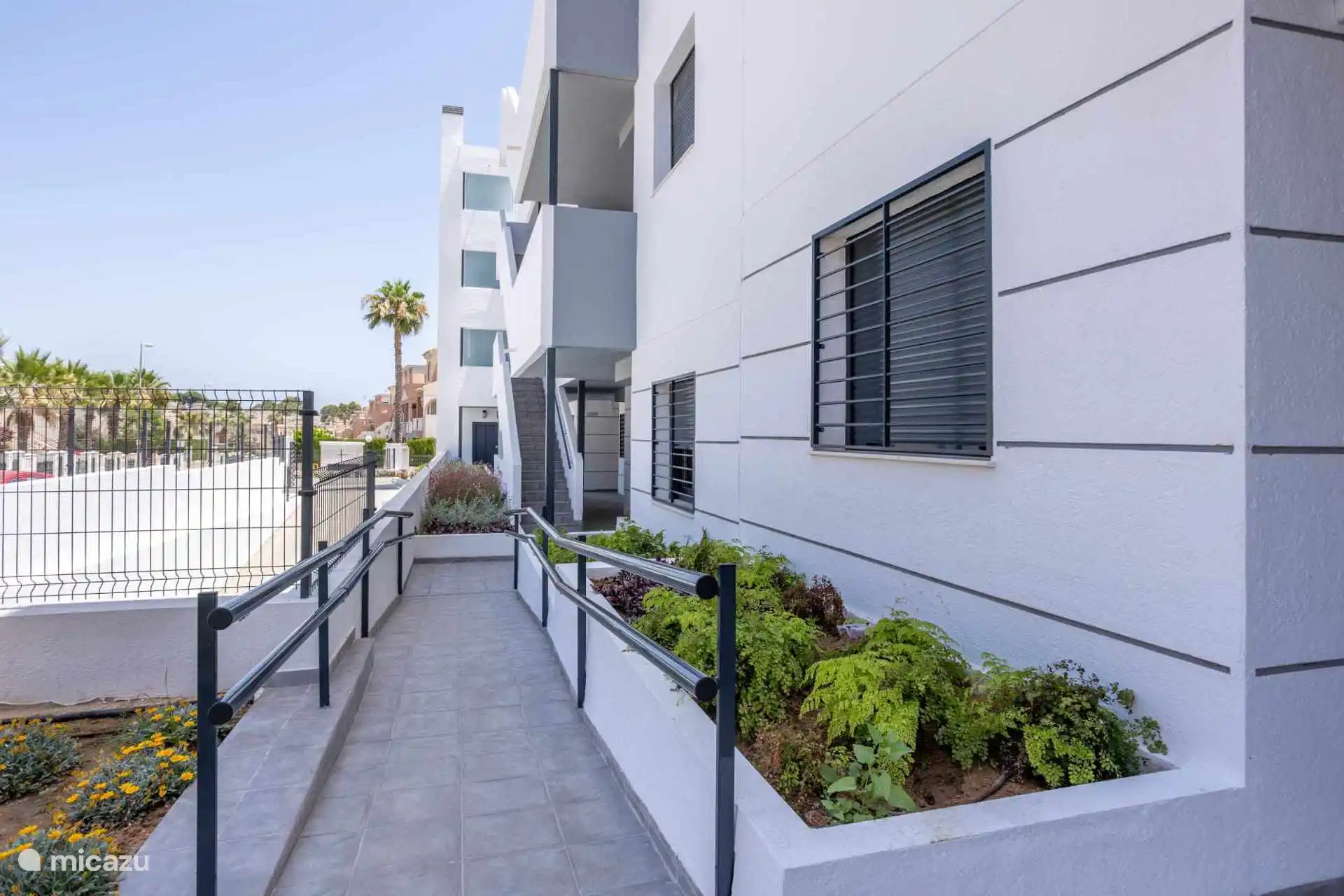 Rückansicht des Komplexes mit Aufzügen und Treppen zu den verschiedenen Etagen. Wieder überall mit schönen Pflanzen geschmückt