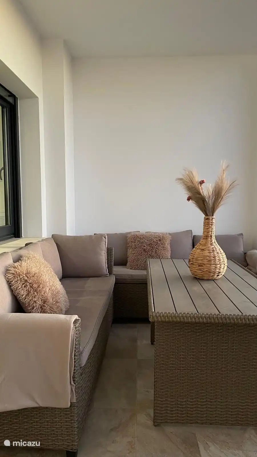 The balcony is equipped with a comfortable seating set. 