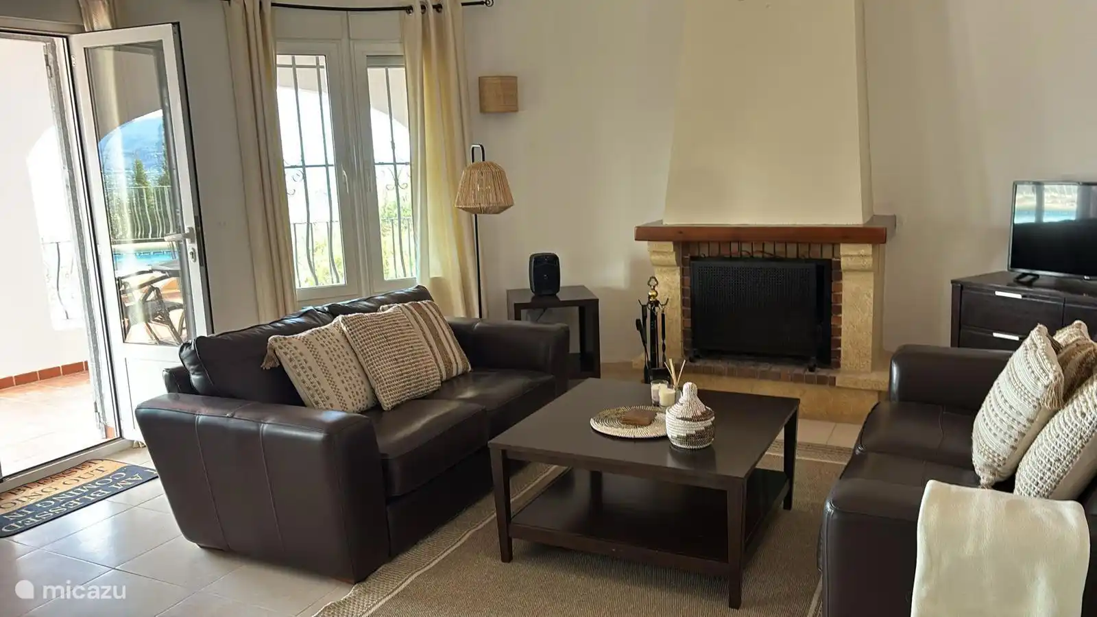 Stilvolles spanisch eingerichtetes Wohnzimmer mit Zugang zur Terrasse, zum Pool und zur Küche.