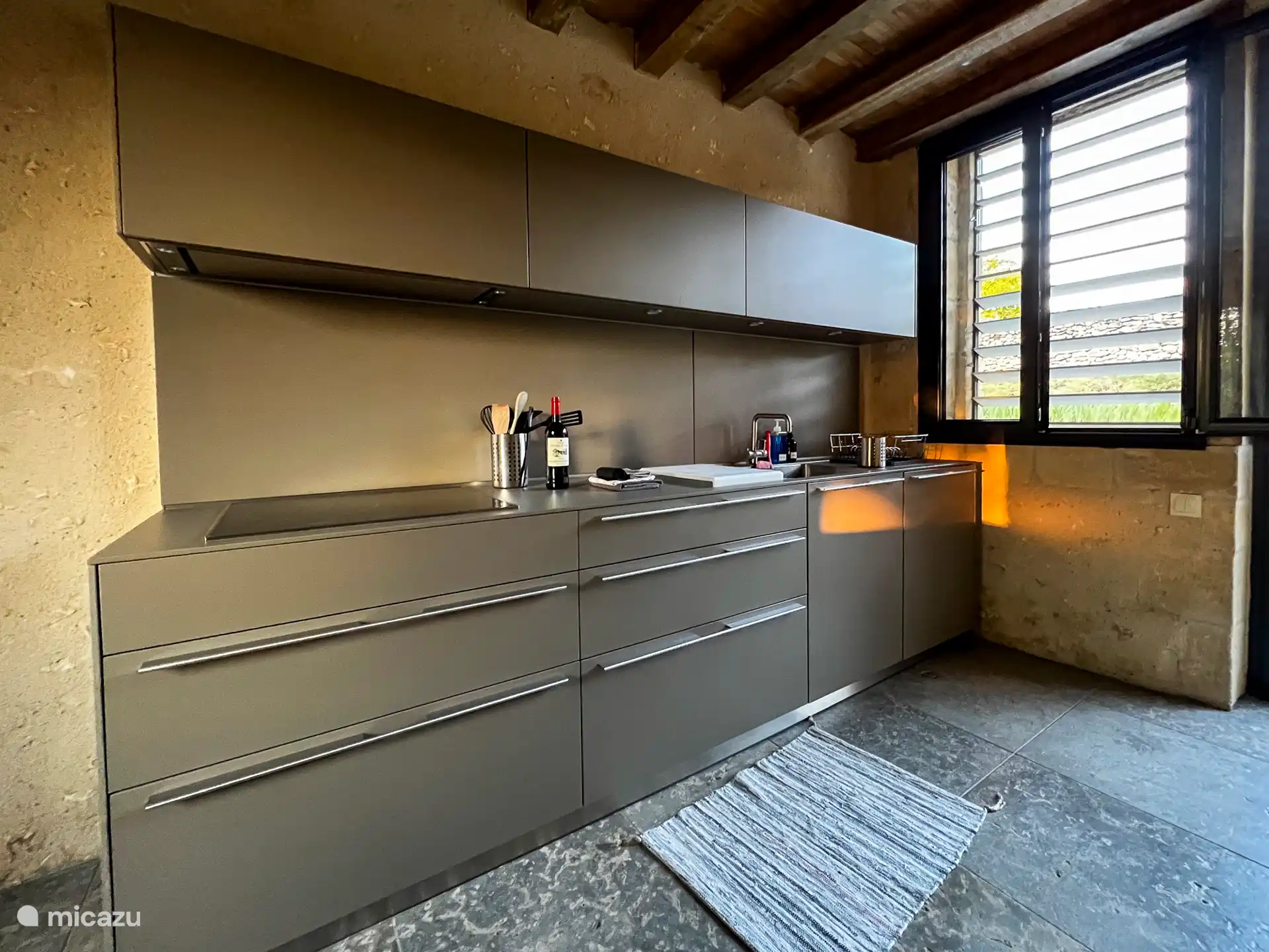 La cocina (1ª parte: vitrocerámica con campana extractora, zona de fregadero y lavavajillas incorporado)