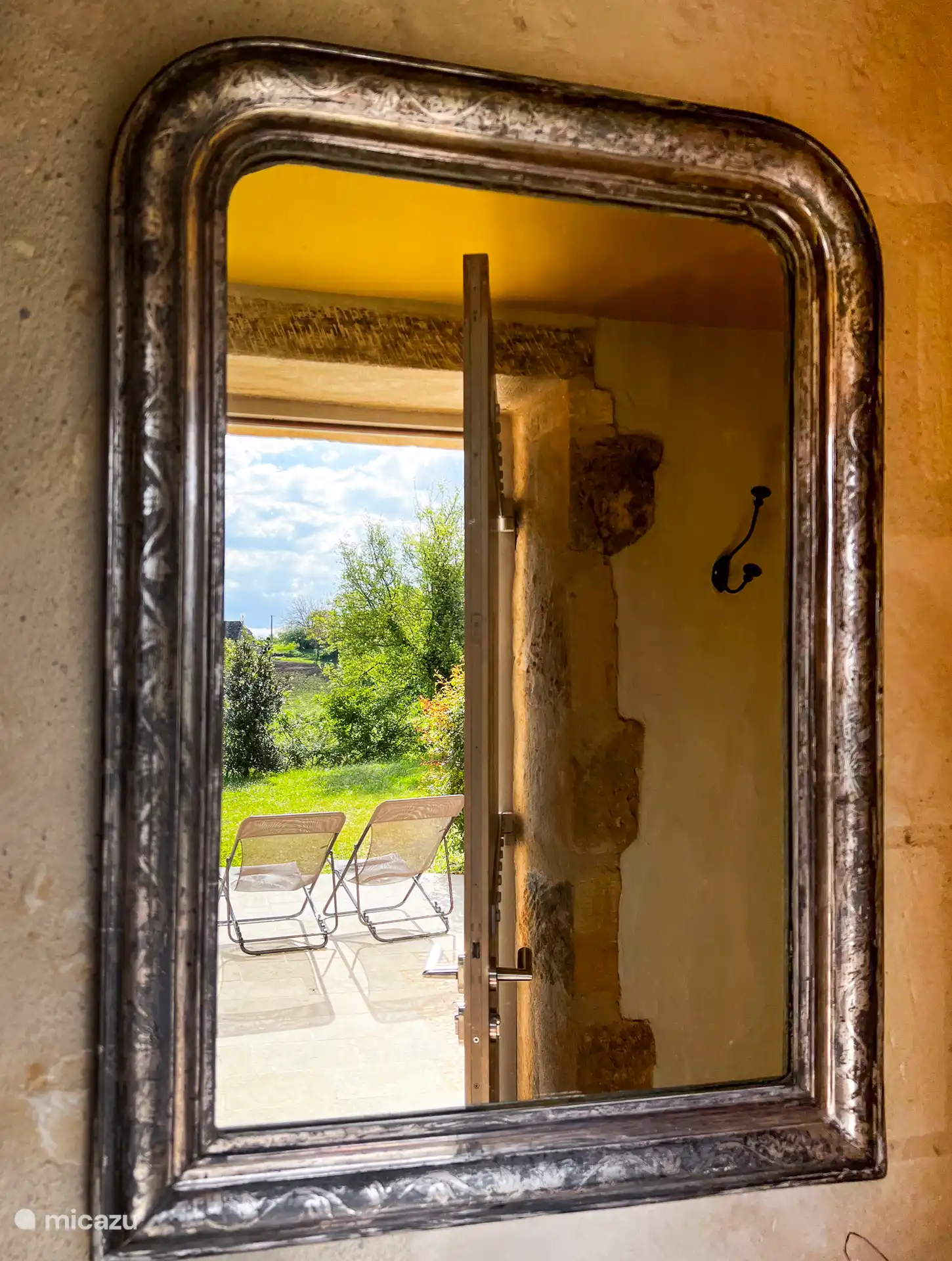 Reflejo de la terraza delantera en el espejo de entrada