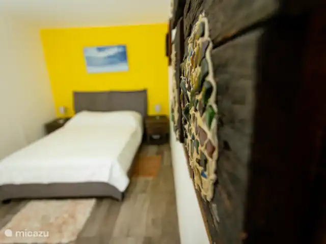 Escapade dans les Caraïbes 1 chambre  | Curaçao, Banda Abou (ouest), Westpunt - appartement Les détails artistiques rencontrent le confort dans la chambre à coucher avec des œuvres d’art murales sur le thème de l’île et des accents naturels.