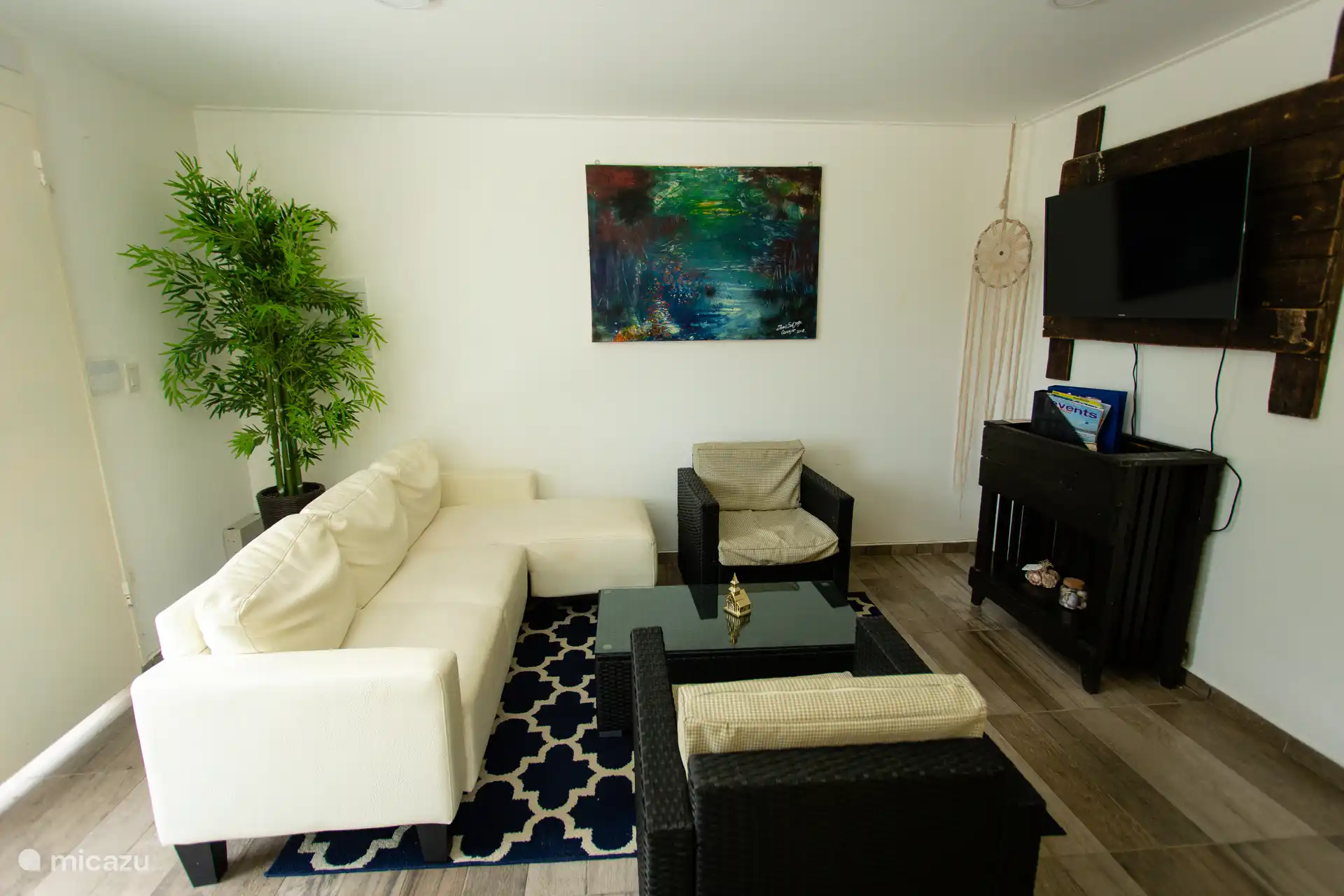 Alternativer Blickwinkel mit Sitzanordnung, Teppich und Dekor für ein modernes tropisches Ambiente.