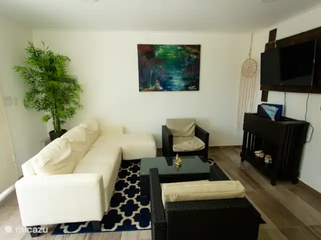 Escapade dans les Caraïbes 1 chambre  | Curaçao, Banda Abou (ouest), Westpunt - appartement Angle alternatif montrant la disposition des sièges, le tapis et le décor pour une sensation tropicale moderne.