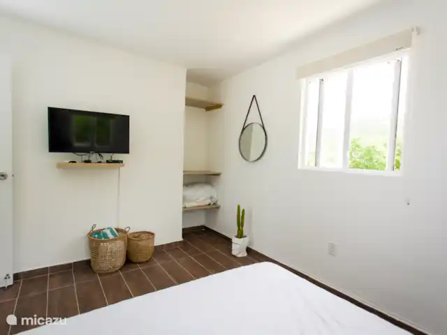 Vue sur l’océan tropical  | Curaçao, Banda Abou (ouest), Westpunt - appartement Fonctionnelle et lumineuse, la chambre dispose d’un espace de rangement ouvert, d’une télévision intelligente et d’une grande fenêtre pour une lumière fraîche.