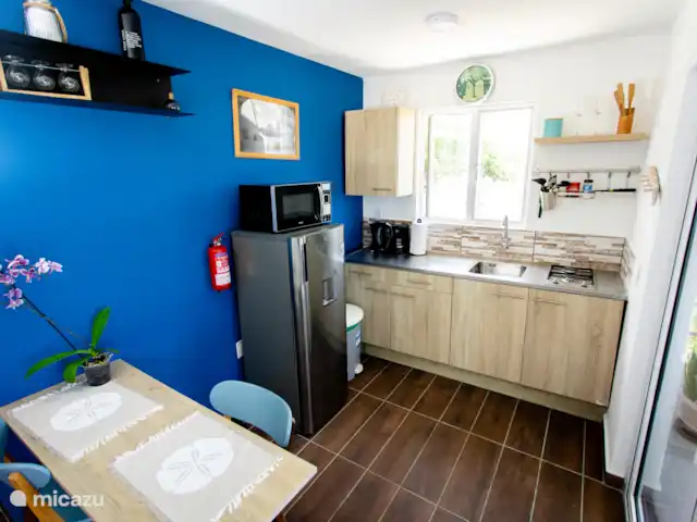 Vue sur l’océan tropical  | Curaçao, Banda Abou (ouest), Westpunt - appartement Cuisine ouverte avec accès direct à la terrasse - cuisinez avec vue sur les collines verdoyantes et la brise de l’océan.