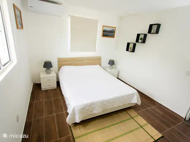Vue sur l’océan tropical  | Curaçao, Banda Abou (ouest), Westpunt - appartement Lit queen-size confortable avec tables de chevet et décoration relaxante pour une bonne nuit de sommeil.
