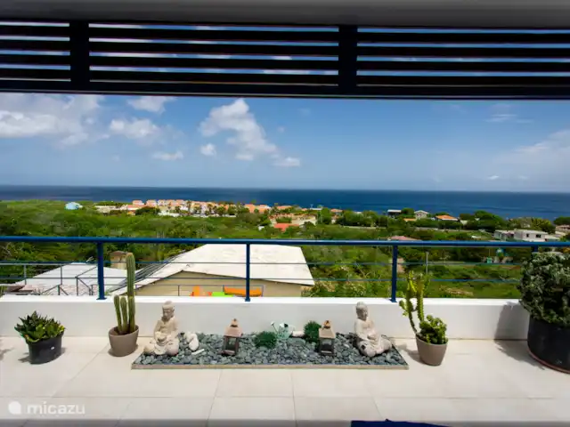 Retraite avec vue sur l’océan tropical | Curaçao, Banda Abou (ouest), Westpunt - appartement Terrasse extérieure spacieuse avec des sièges de salon et une ambiance tropicale détendue.