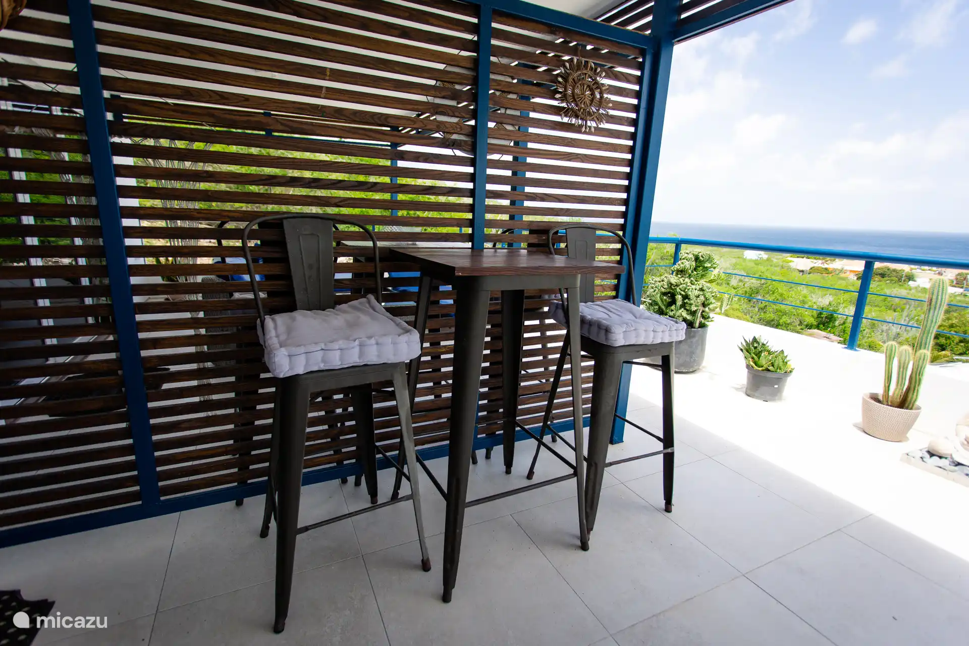 Privater Balkon mit Hochstühlen und Tisch für einen intimen Drink mit Meeresbrise.