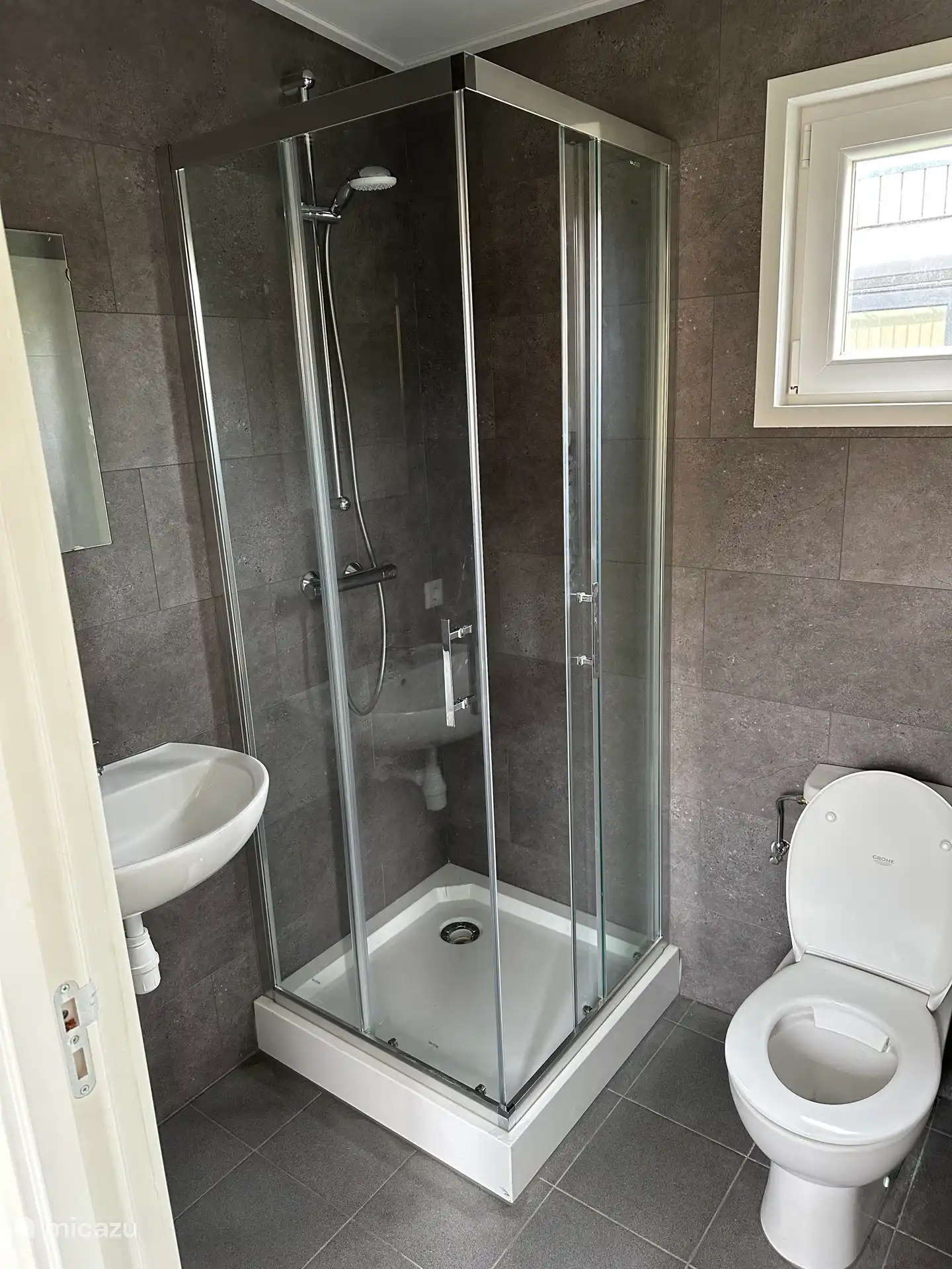 Badezimmer mit Dusche, WC und Waschbecken mit Unterschrank