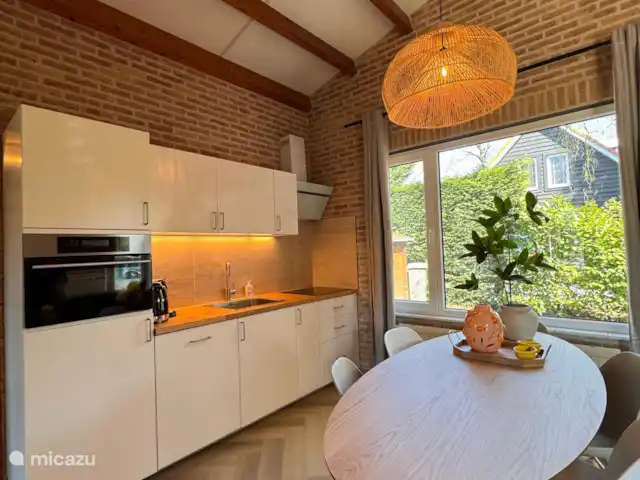 Villa Frans | Pays-Bas, Zélande, Renesse - maison de vacances Cuisine moderne avec des éléments naturels, beaucoup de lumière du jour et une vue sur la verdure. Ici, vous pouvez cuisiner détendu avec une touche de Zélande.