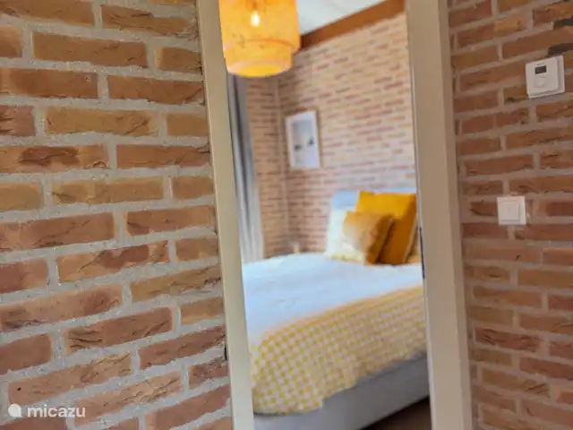 Villa Frans | Pays-Bas, Zélande, Renesse - maison de vacances Une vue à travers une chambre confortable avec des accents jaunes joyeux. Atmosphérique, chaleureux et accueillant.