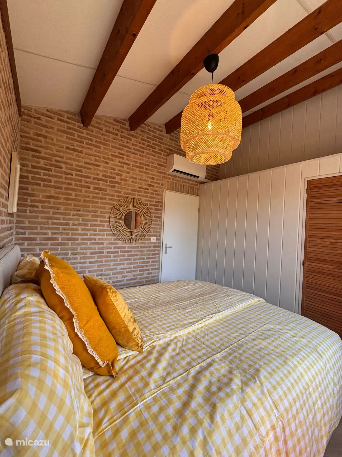 Geräumiges Schlafzimmer mit Klimaanlage und attraktiven Holzakzenten. Hier schläft man wunderbar kühl und gemütlich.