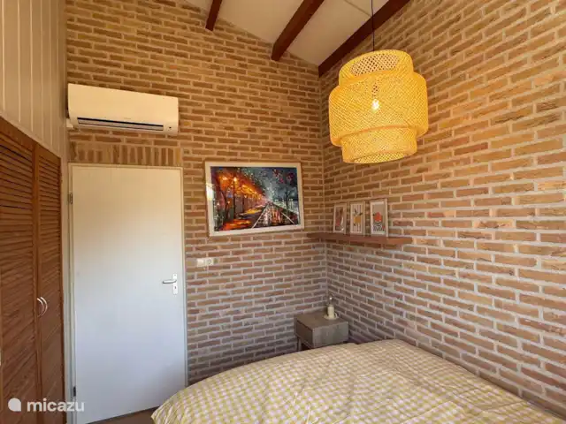 Villa Frans | Pays-Bas, Zélande, Renesse - maison de vacances Des murs de briques chaleureux, une œuvre d’art joyeuse, une belle climatisation et une grande armoire encastrée le complètent.