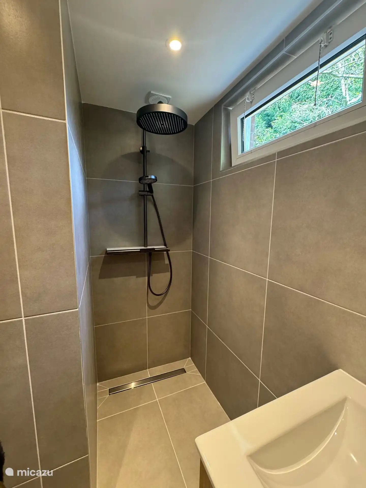 Geräumige begehbare Dusche mit moderner Regendusche. Hier starten Sie erfrischt und entspannt stilvoll in den Tag.