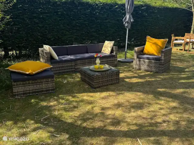 Villa Frans | Pays-Bas, Zélande, Renesse - maison de vacances Coin salon avec coussins colorés et parasol. Parfait pour des moments de détente dans le jardin.