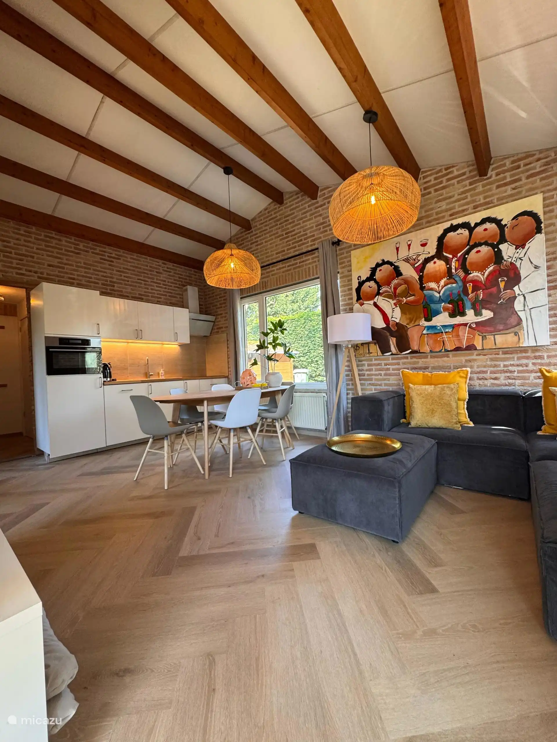 Gemütliches Wohnzimmer mit Holzbalken, warmen Farben und einem fröhlichen Kunstwerk. Hier spürt man sofort: Das ist Urlaub!