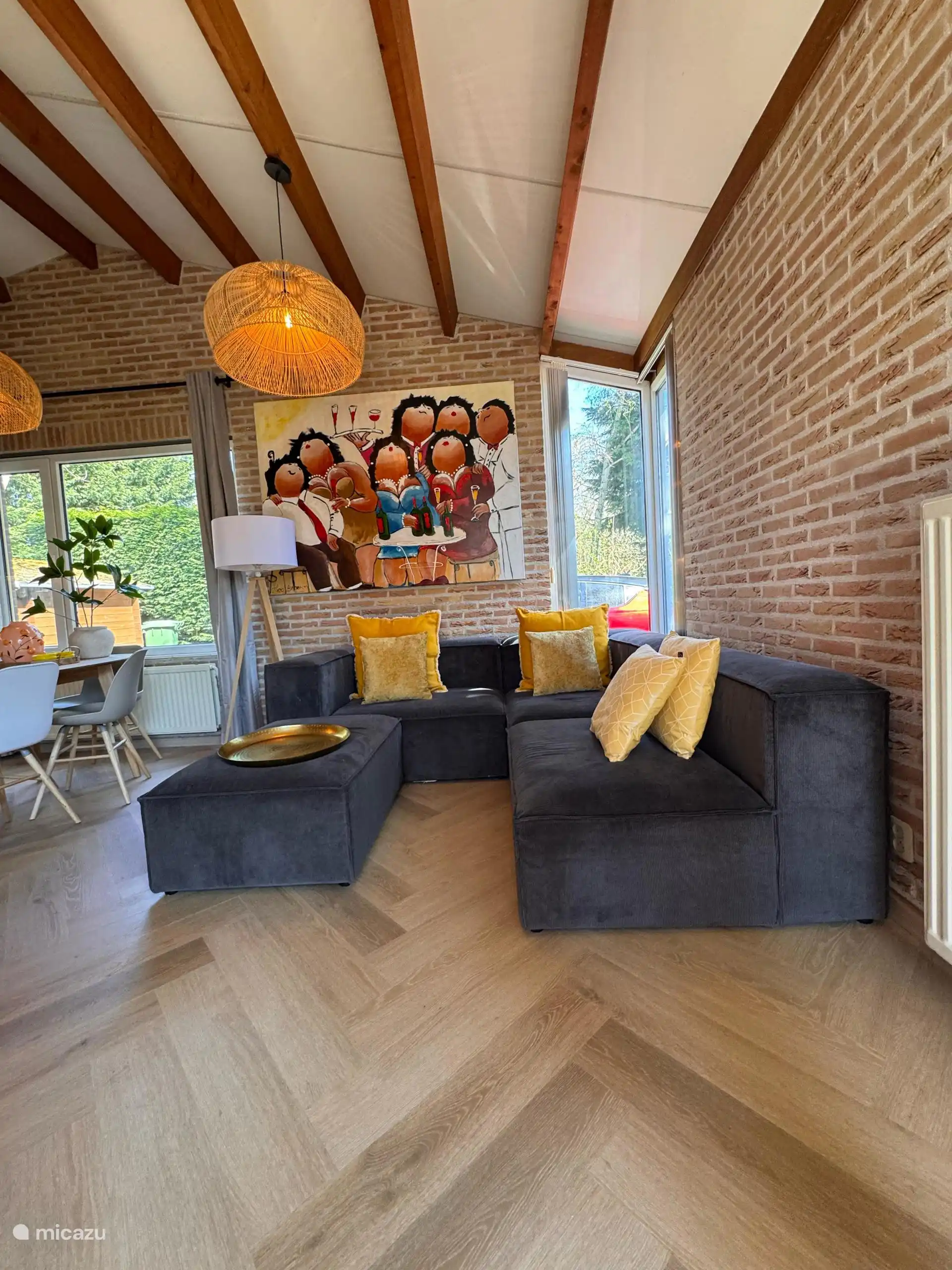 Gemütliche Sitzecke mit großen Fenstern, weichen Kissen und viel Licht. Ideal zum Faulenzen mit einem Buch oder einem guten Glas Wein.