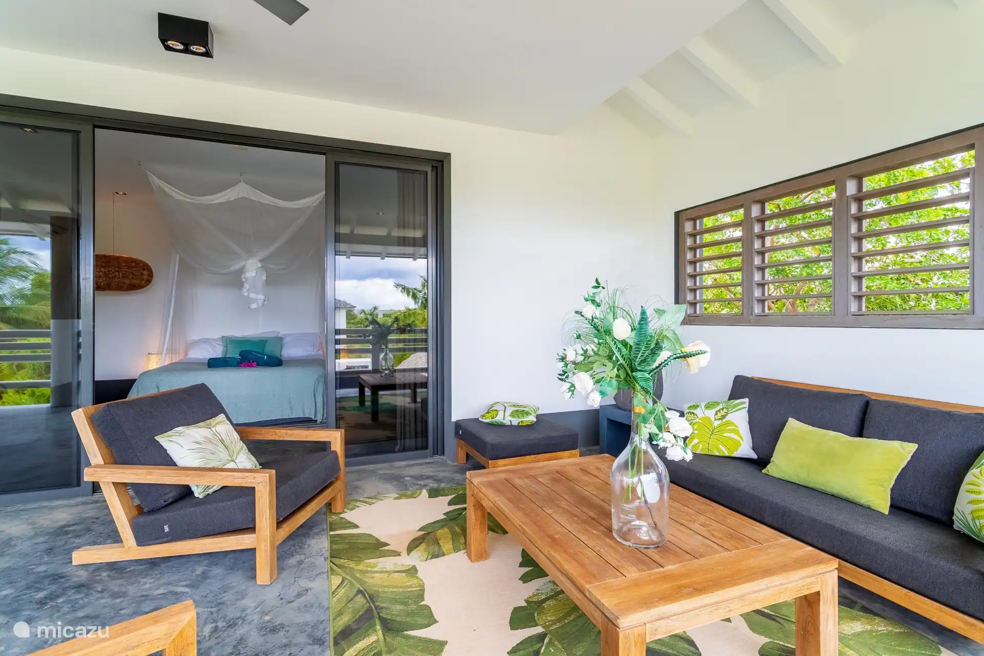 The bedroom at the rear gives access to a large balcony with comfortable seats and hanging chairs.