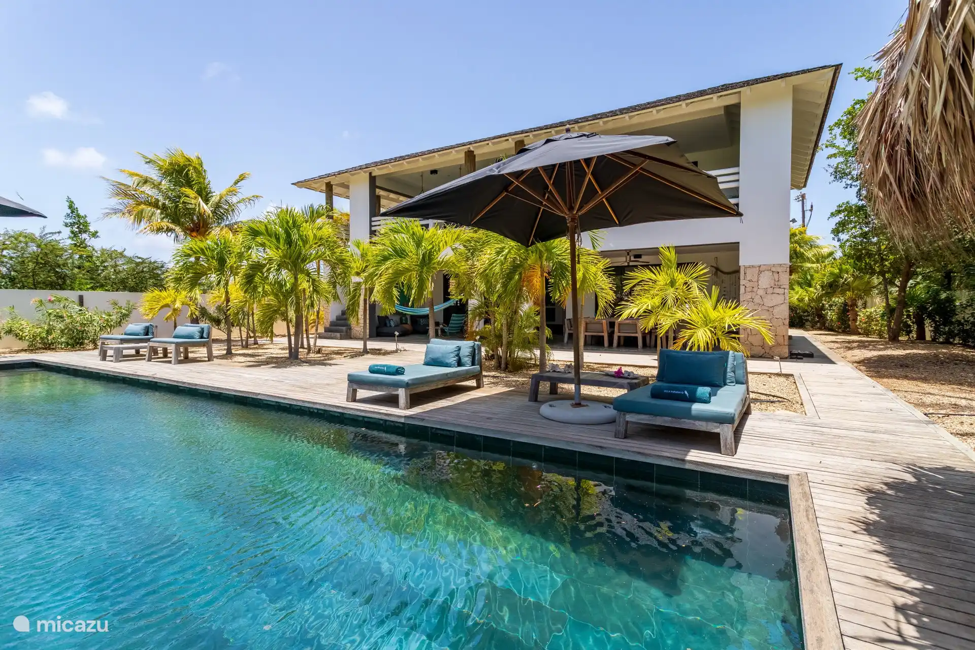 Around the pool there are several lounge beds and umbrellas.