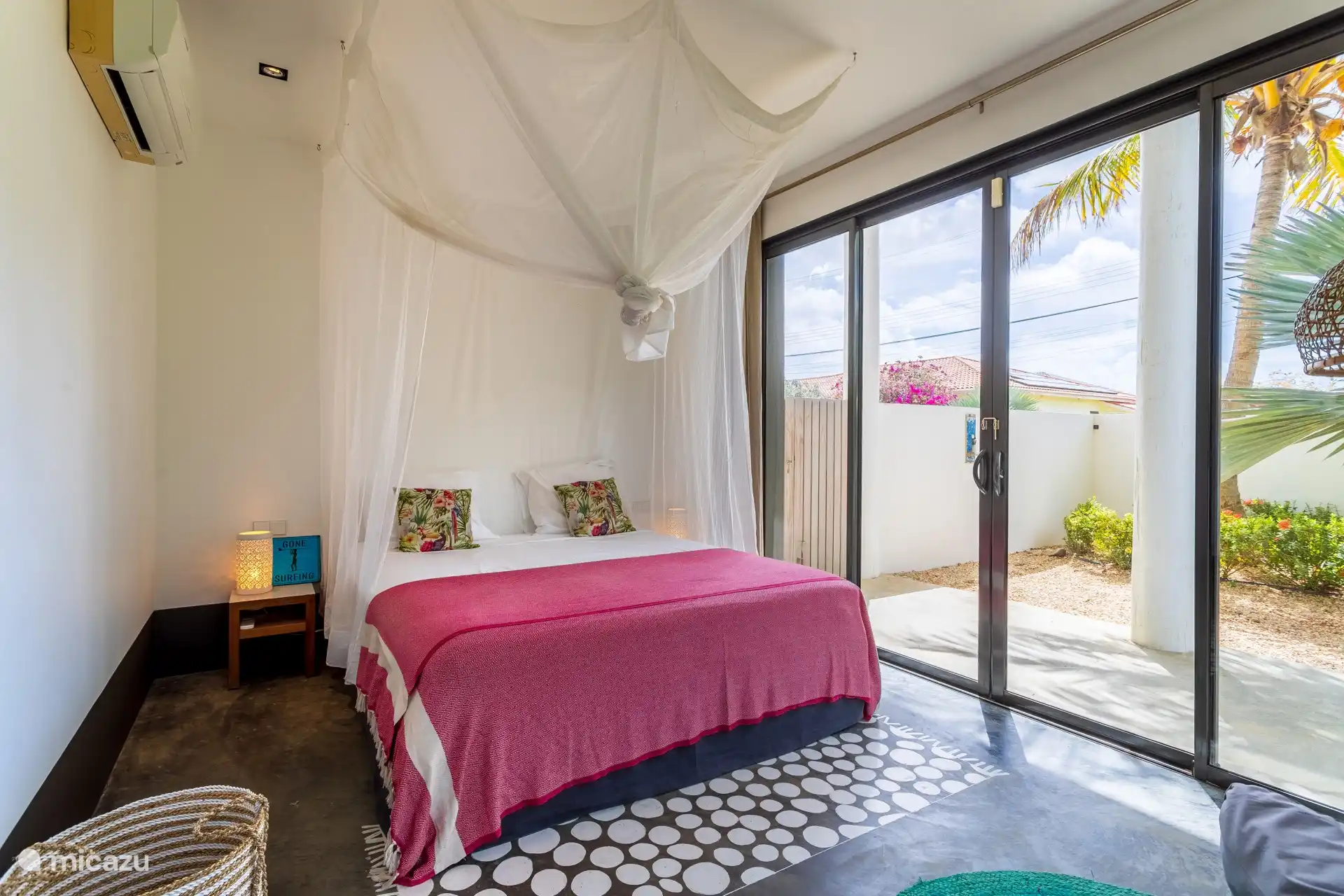 The bedroom on the ground floor has a king size bed with mosquito net and AC. With an ensuite shower and sliding doors to the garden.