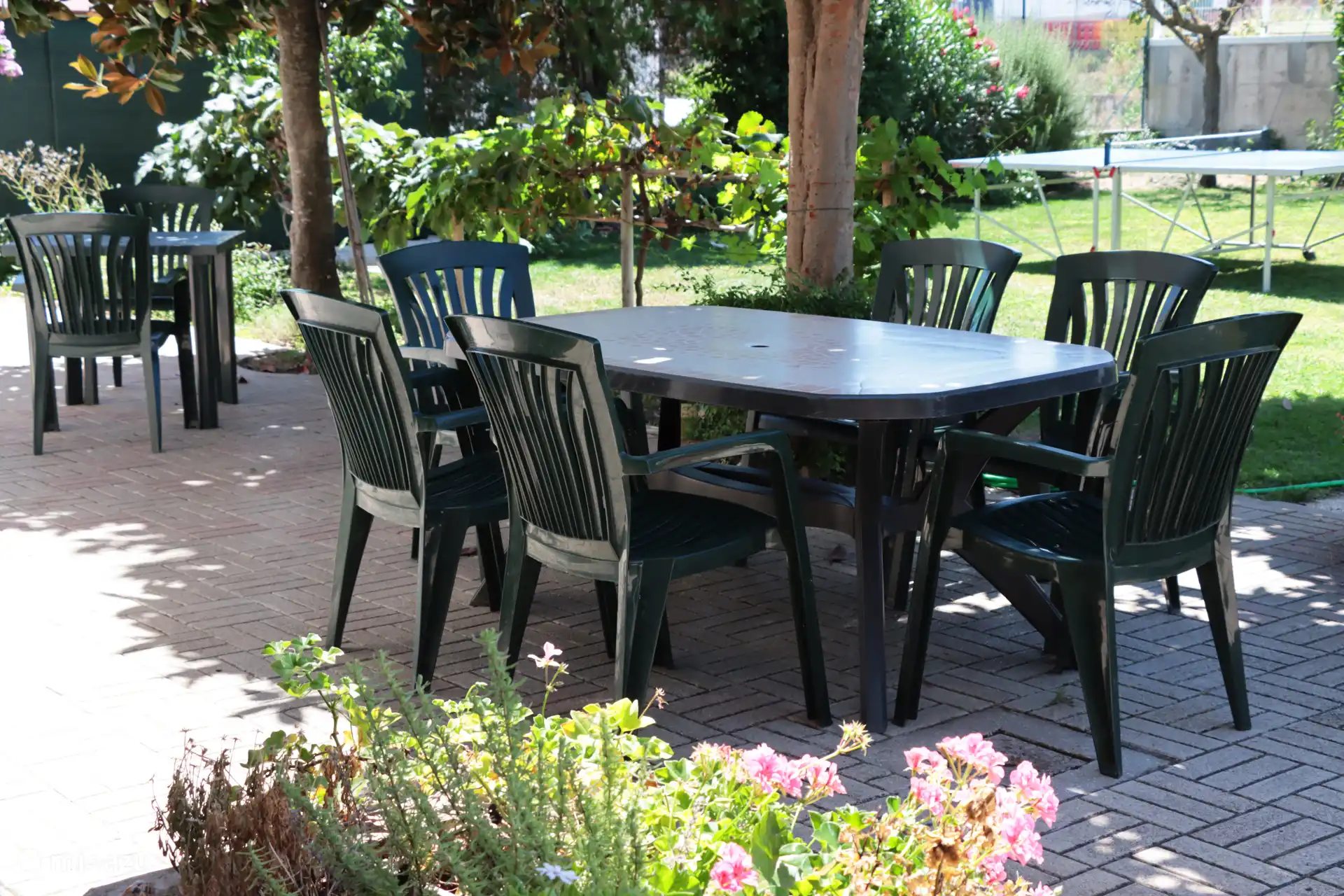 La mesa del jardín a la sombra del níspero, para charlar o comer algo al aire libre.