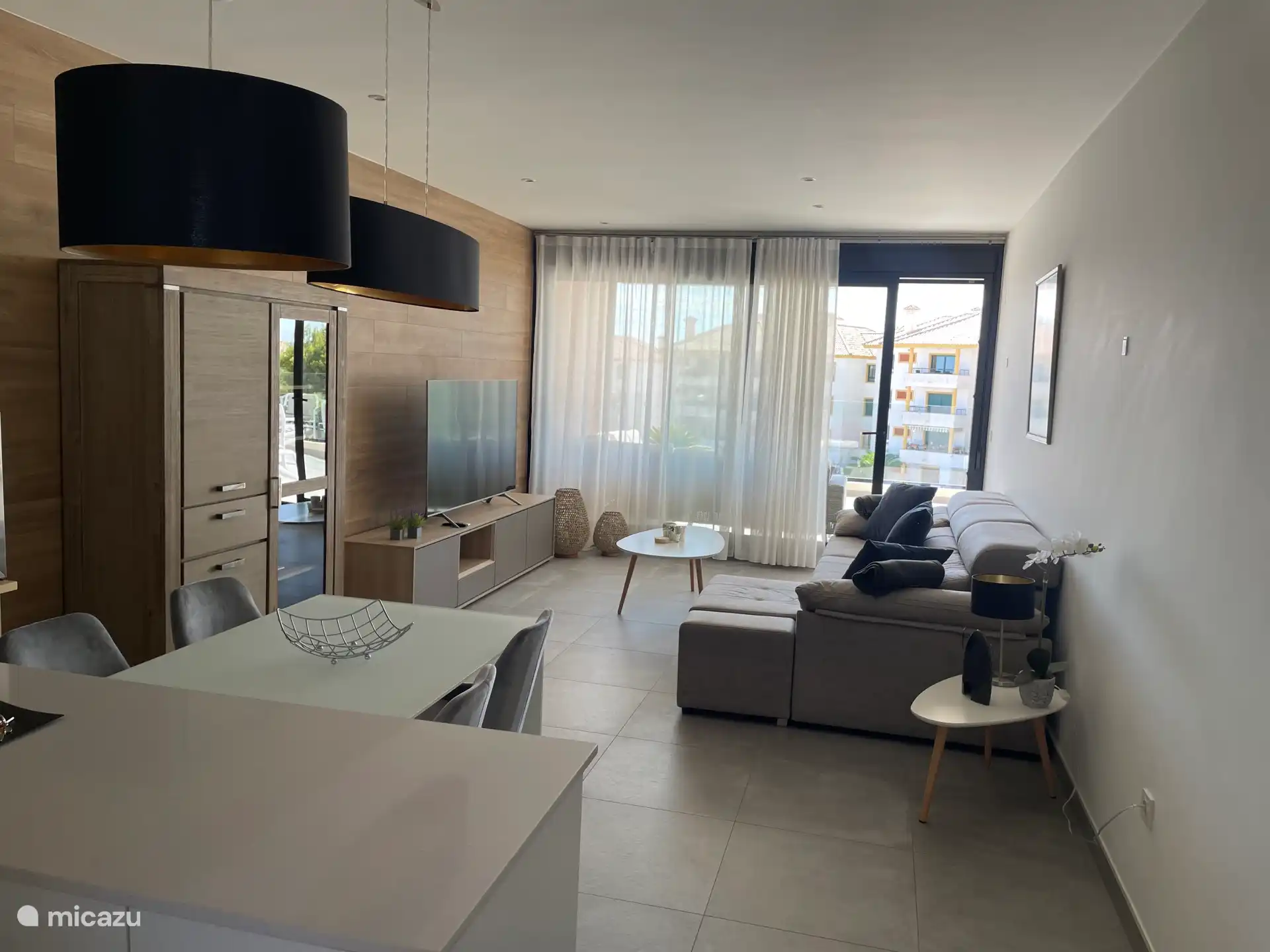 Wohnzimmer mit Smart-TV und Zugang zur Terrasse