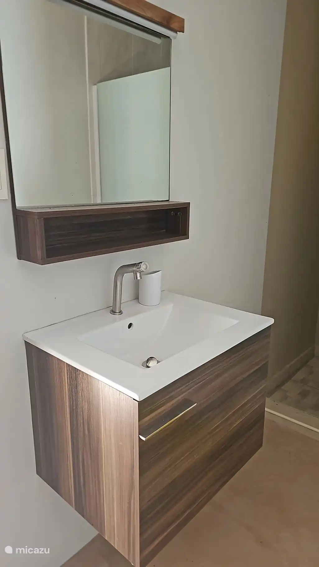 shower with mirror, sink and cupboard.