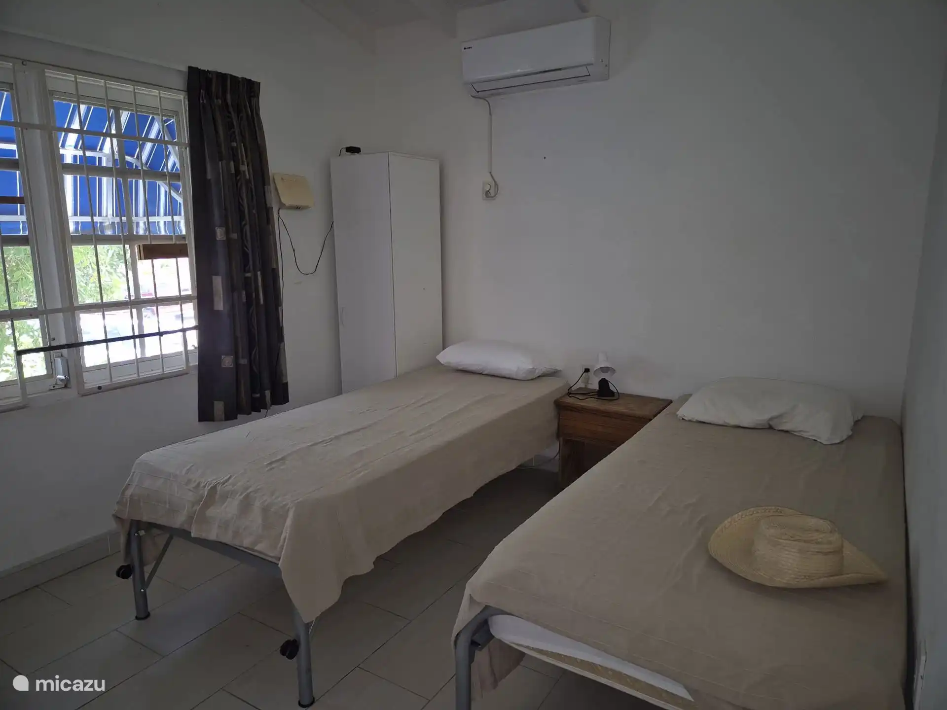 Dormitorio con aire acondicionado, camas y armario