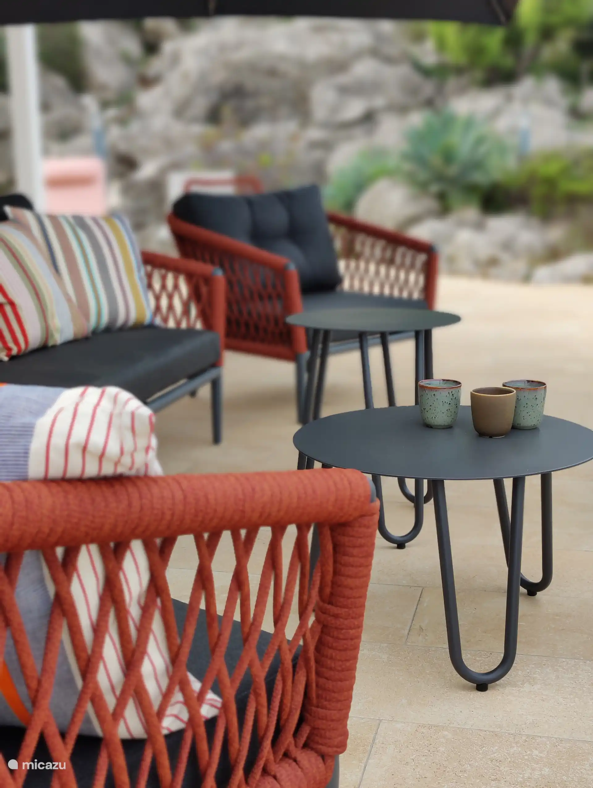 Comfortable garden furniture with a view of the rock garden and the swimming pool.